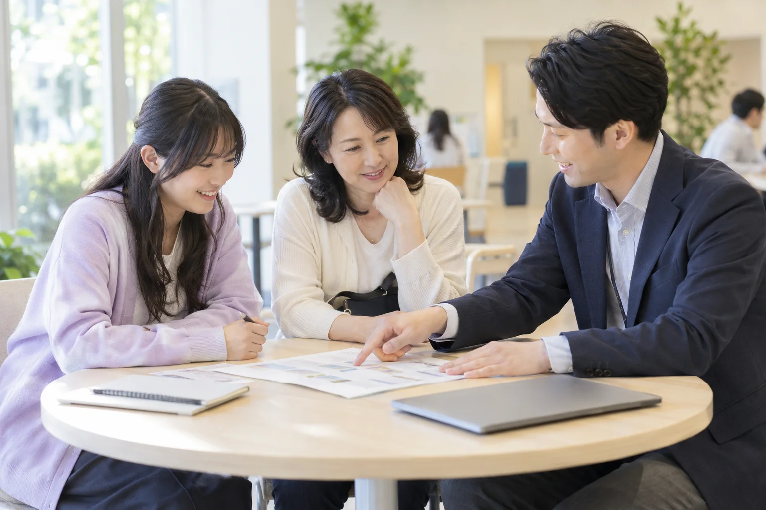 本人と母親が先生と同じテーブルを囲み、学びや進路について相談する架空の個別相談の風景。